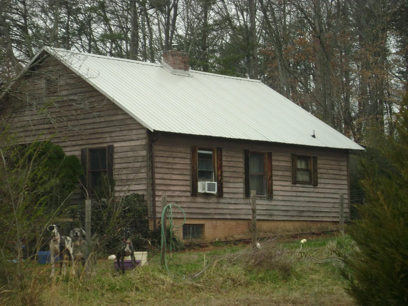 White metal roof on an old wood sided farmhouse, from a Metal Roof Installation job in Sutton